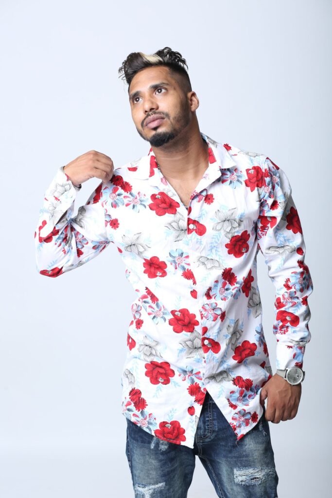 Man in a printed floral shirt posing in a studio